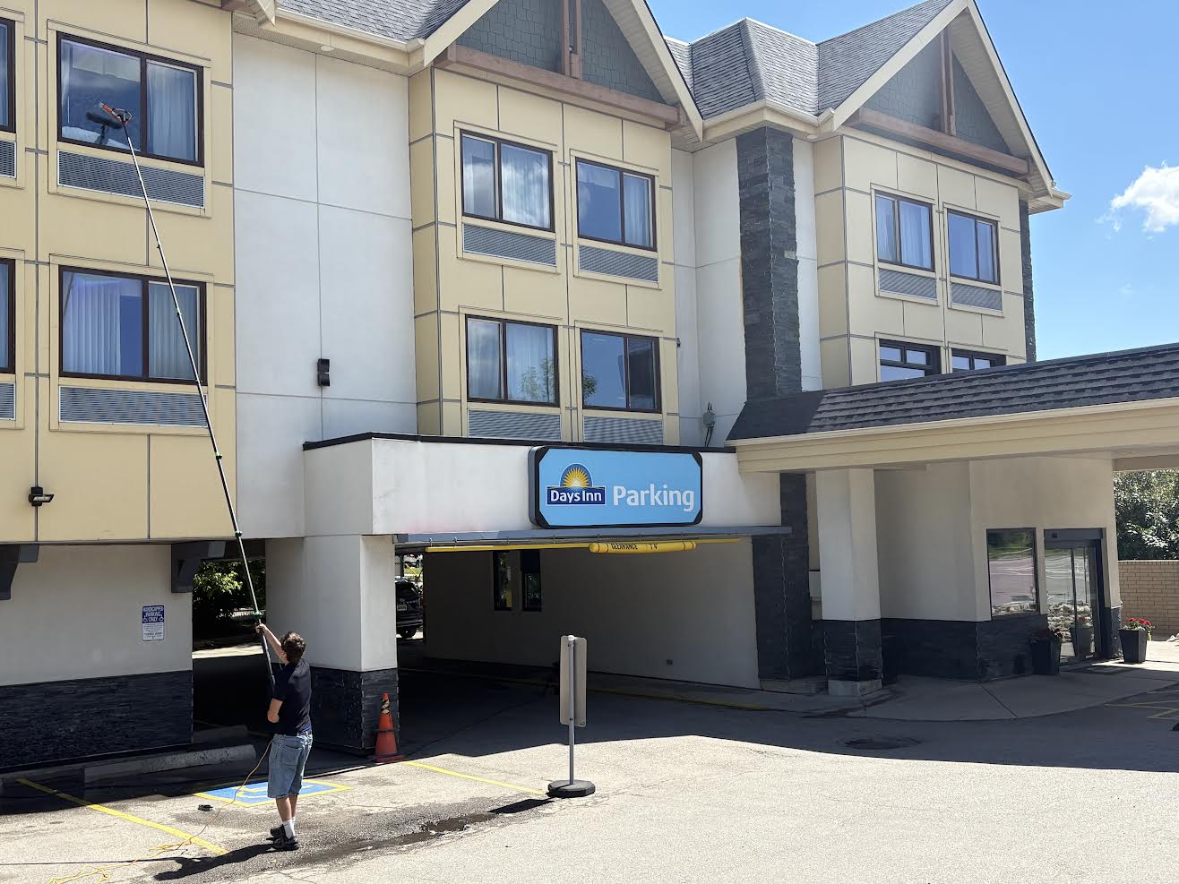 Daniel cleaning windows at a Calgary hotel with a water-fed pole