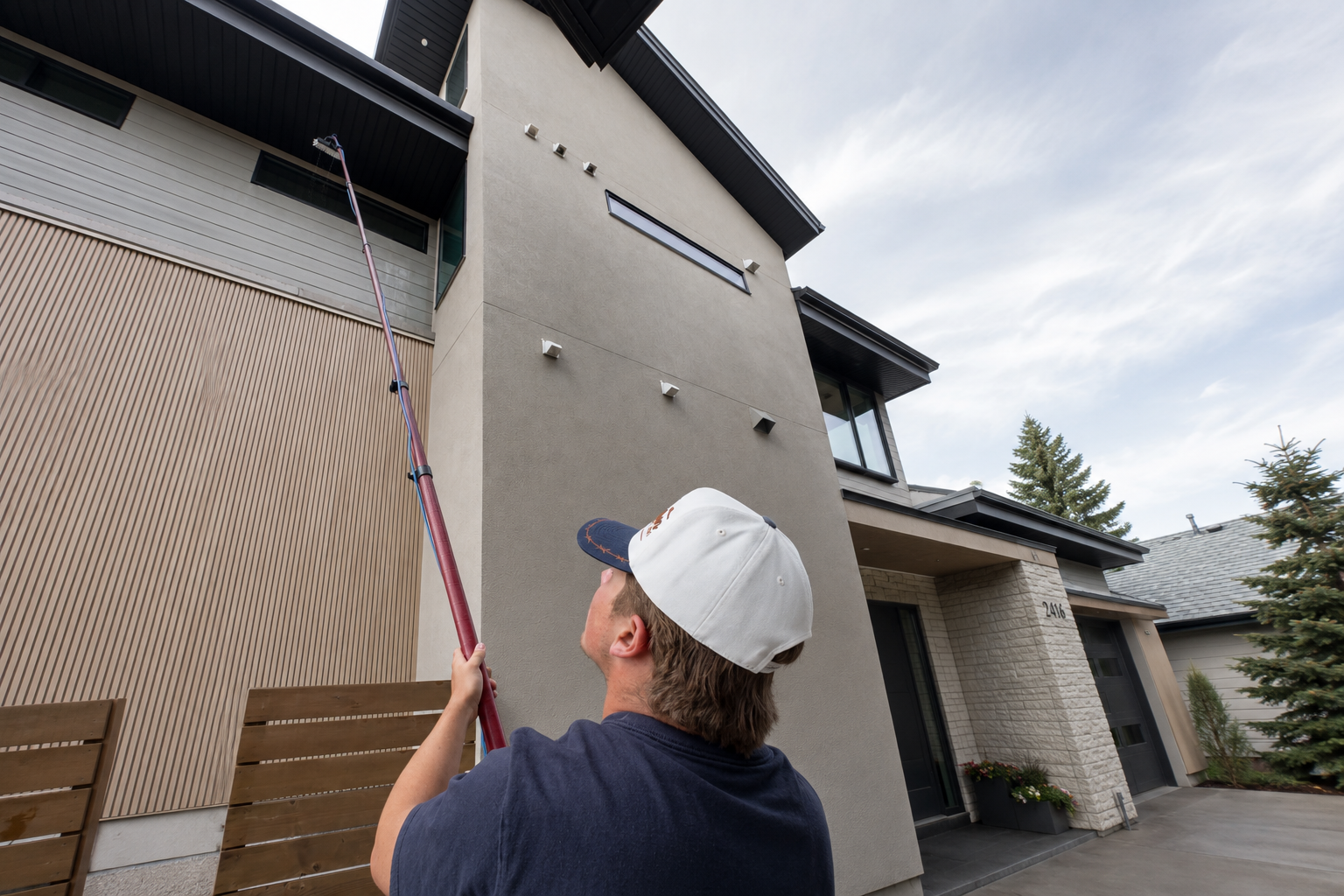 Daniel cleaning high windows with a water-fed pole in Calgary